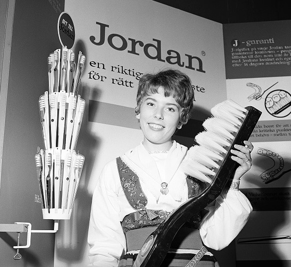 Women holding a prop toothbrush at a trade show
